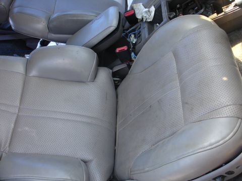 1993 Ford Taurus - Interior view of worn gray car seats, including seat belts and a section of the dashboard.