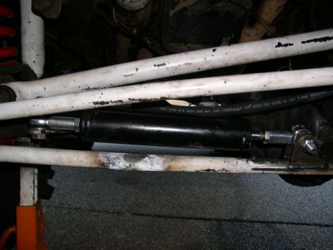1979 Ford Bronco - Close-up of a power steering assist cylinder, likely an aftermarket part.