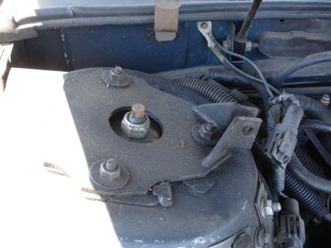 1993 Ford Taurus - Close-up view of a vehicle's engine bay, focusing on the strut mount assembly.