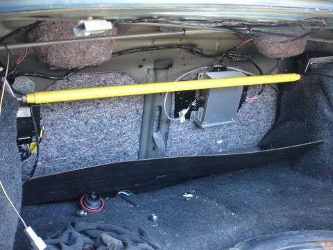 1993 Ford Taurus - The trunk interior shows a yellow strut bar and a gray electronics box mounted on the side panel.