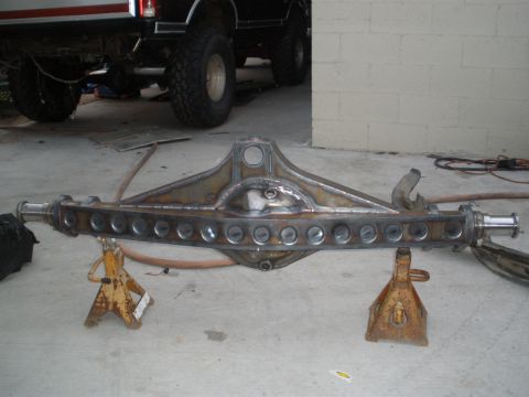 1995 Ford Bronco - A custom rear axle assembly is shown on jack stands, with a lifted truck partially visible in the background.