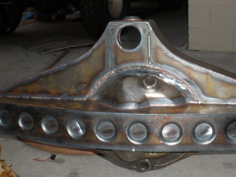 1995 Ford Bronco - A custom-fabricated rear axle housing is shown, numerous circular cutouts along its length and prominent welding work.