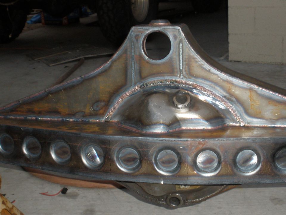 Custom rear axle housing with circular cutouts and visible welds