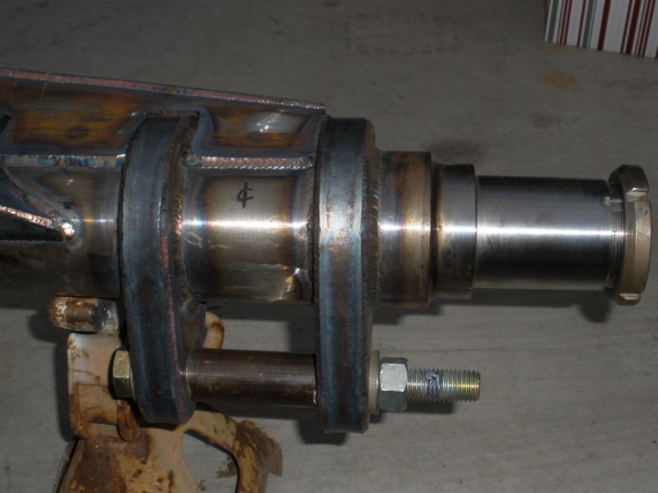 Close-up of a fabricated rear axle assembly supported by a jack stand