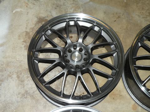 1998 Subaru Legacy - Set of aftermarket alloy wheels shown on a concrete floor.