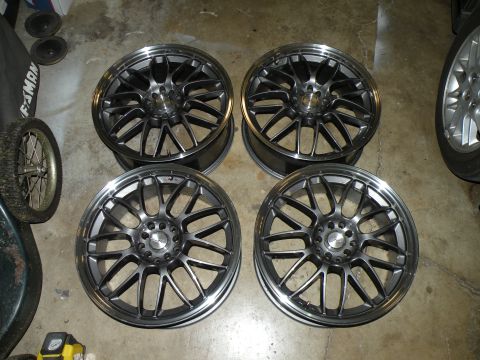 1998 Subaru Legacy - A set of four aftermarket wheels are displayed on a concrete floor.