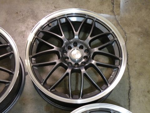 1998 Subaru Legacy - Four aftermarket alloy wheels are shown on a concrete floor.