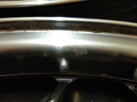 1998 Subaru Legacy - A close-up view of a damaged and dirty silver wheel rim.