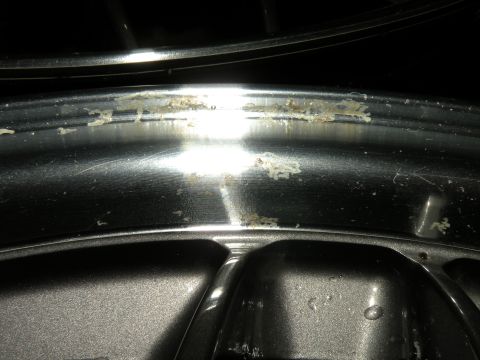 1998 Subaru Legacy - This image shows a close-up of a wheel rim with debris and some scratches.