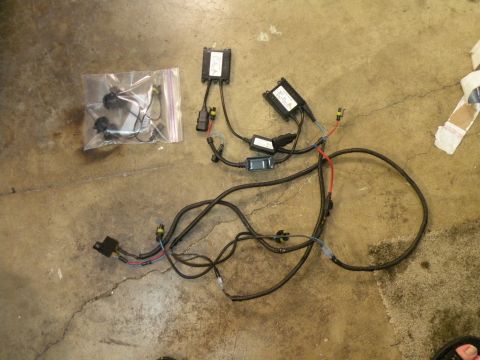 1998 Subaru Legacy - HID ballast and wiring harness kit with connectors and ballast boxes on a concrete floor.