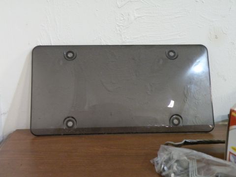 1998 Subaru Legacy - A dark tinted license plate cover is shown against a textured wall.