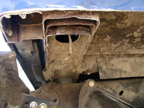 1979 Ford Bronco - Close-up view of heavily rusted and damaged vehicle frame components, indicating poor condition.