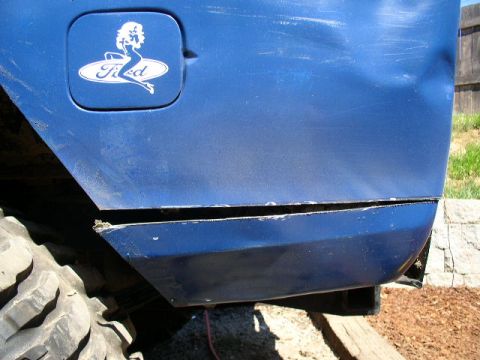 1979 Ford Bronco - A blue 1979 Ford Bronco shows off its rear quarter panel, a 'Ford' logo with a pin-up girl decal.