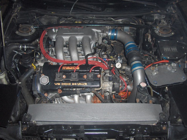 Mazda V6 DOHC 24-valve engine bay with red plug wires and blue intake hose