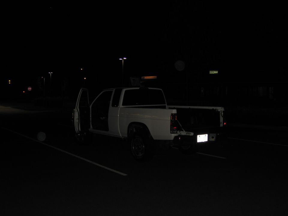 White pickup truck with doors open at night