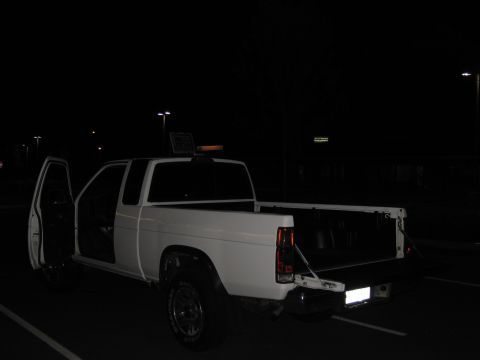 2001 Ford Crown Victoria - White pickup truck parked at night with driver's side door and tailgate open.