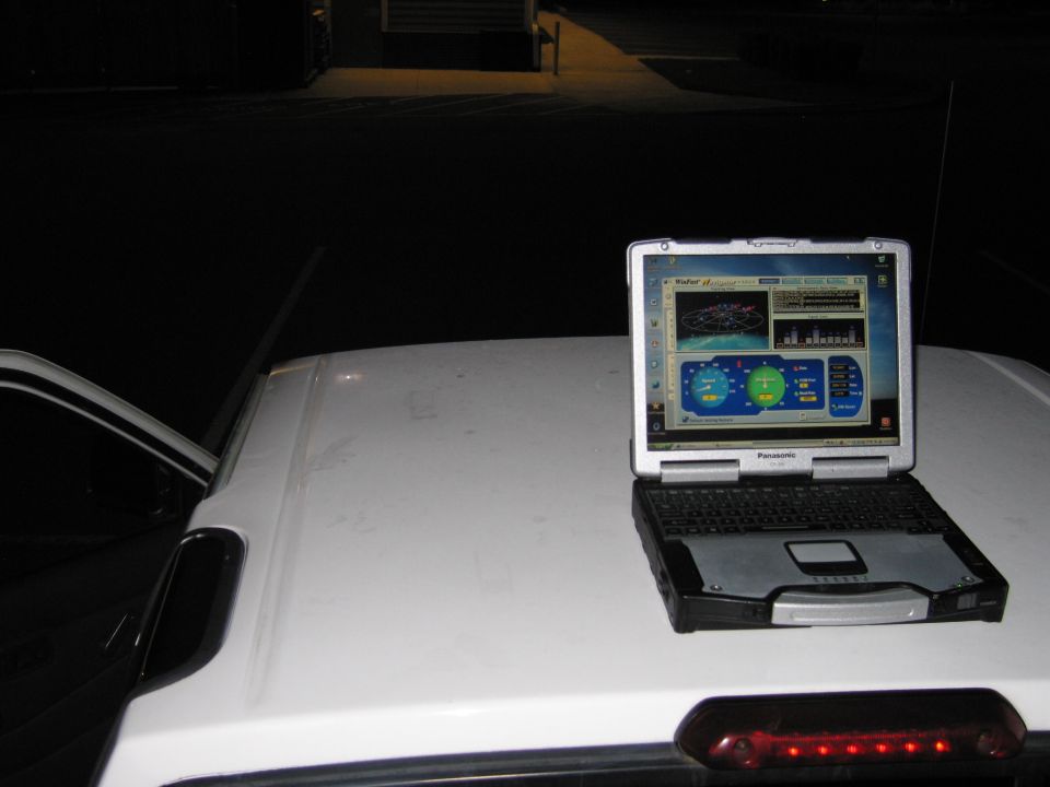Laptop computer on white car roof displaying GPS software