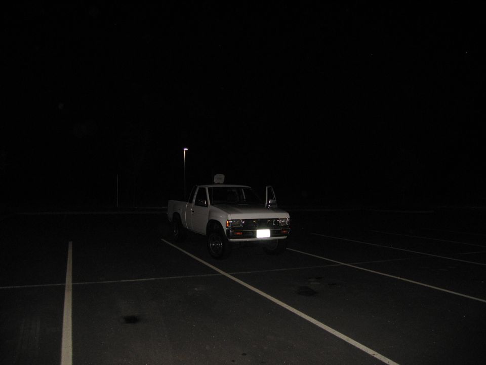 White pickup truck parked in a lot at night