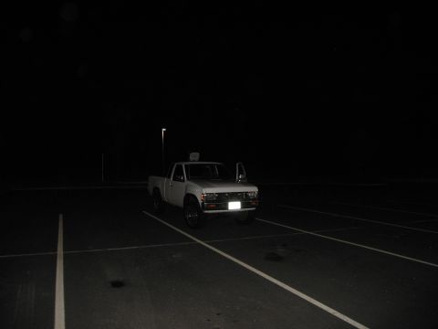 2001 Ford Crown Victoria - White pickup truck parked in a lot at night with the driver's door open.