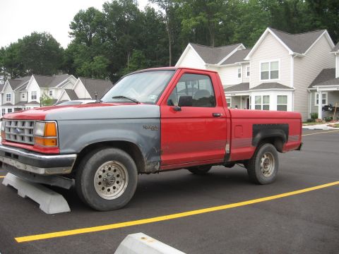 1992 Ford Ranger - This pickup truck has a red cab and bed with a gray front end.