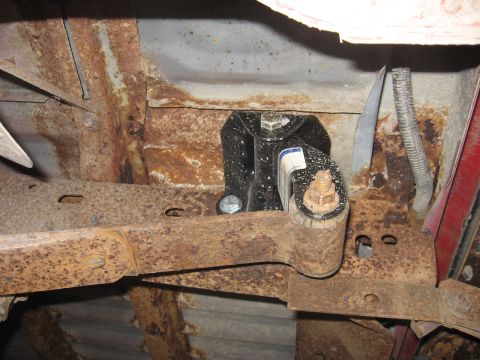 1992 Ford Ranger - Close-up view of the heavily rusted undercarriage of a vehicle, showing a black bracket and fasteners.