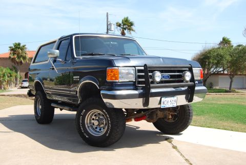 1991 Ford Bronco - This 1991 Ford Bronco features a bull bar and is parked outside a residential building.
