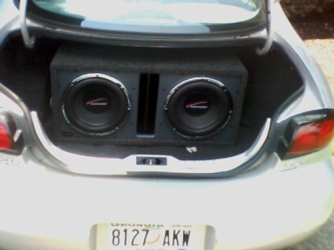 1998 Ford Taurus - The rear of a silver car shows a trunk with a large subwoofer box containing two speakers.