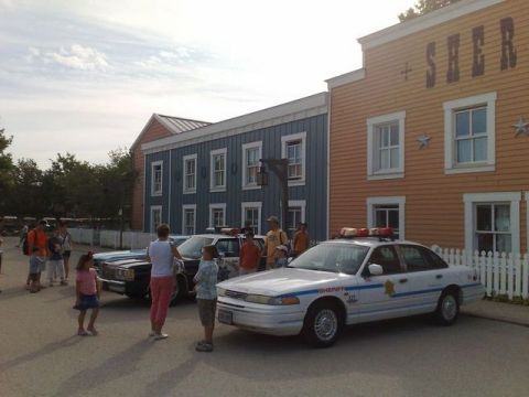 1991 Ford LTD Crown Victoria - Two police cars are parked in front of a building with 'SHERIFF' signage.
