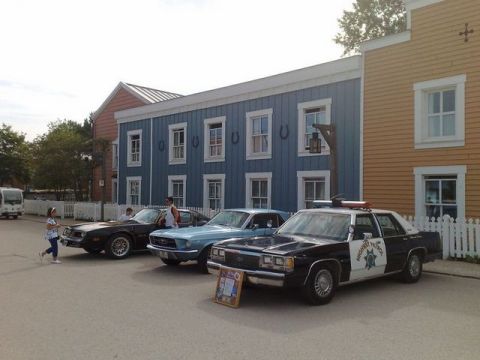 1991 Ford LTD Crown Victoria - A police car from the 1980s is parked in front of a themed building.