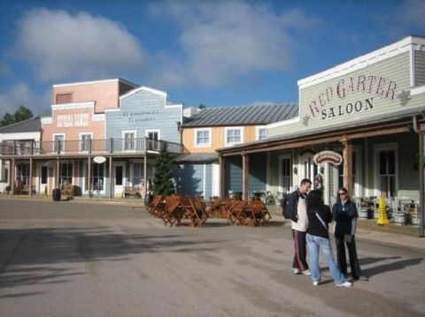 1991 Ford LTD Crown Victoria - A western-themed town square scene with buildings and a few people.