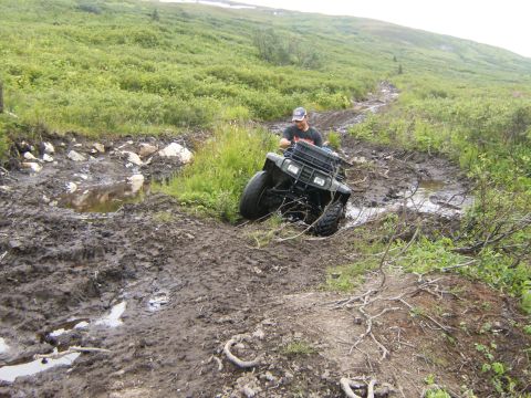 2000 Ford E350 - All-terrain vehicle struggling through deep mud on an off-road trail.