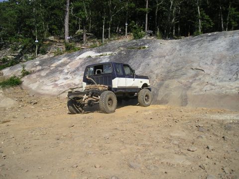 1989 Ford Bronco - This 1989 Ford Bronco is shown off-roading with its rear chassis exposed, highlighting its capabilities.