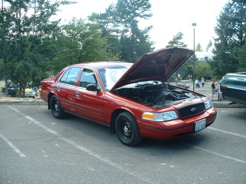 1999 Ford Crown Victoria - A red sedan, likely a Ford Crown Victoria from the early 2000s, is parked with its hood open.