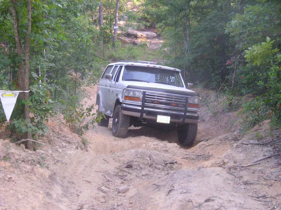 Silver SUV with a brush guard driving on a dirt trail