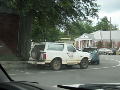 1978 Ford Bronco - White Ford Bronco from the 1990s parked in a lot with other vehicles.