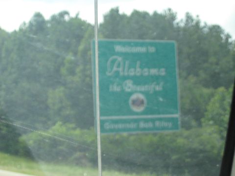 1978 Ford Bronco - A sign indicating entry into Alabama is visible through a vehicle window, with trees in the background.
