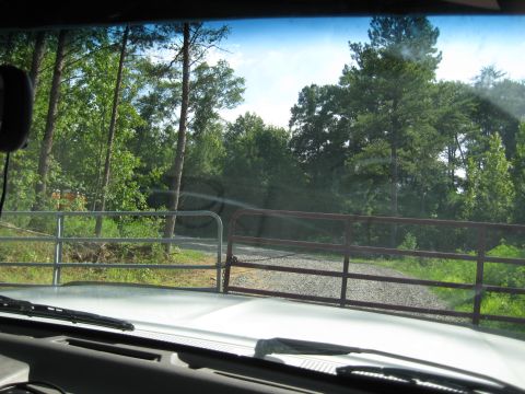 1978 Ford Bronco - Driving up a gravel driveway towards a closed gate, with trees on either side.