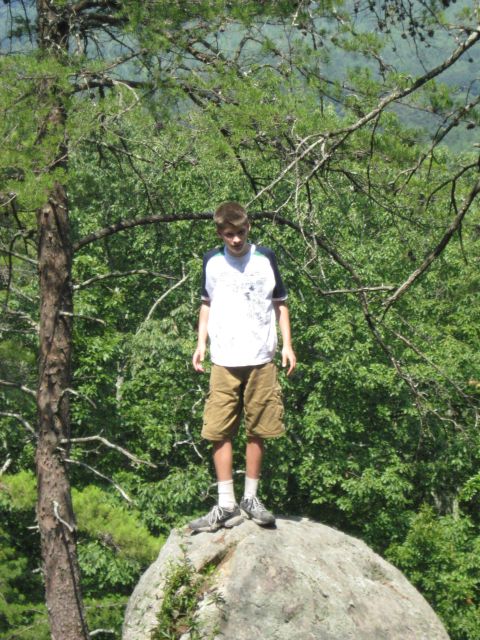 1978 Ford Bronco - Boy on a rock overlooking a wooded area.