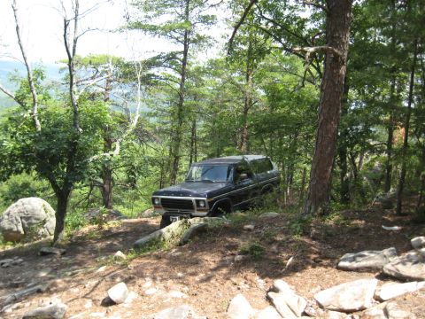 1978 Ford Bronco - A black 1978 Ford Bronco navigates a rocky, wooded trail.