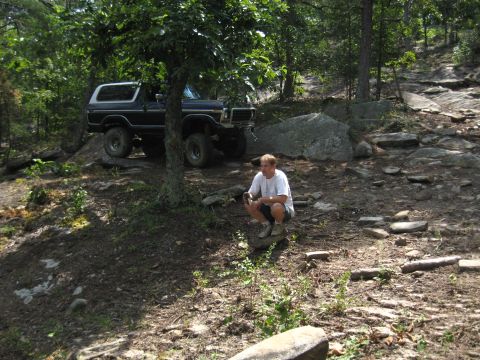 1978 Ford Bronco - 1978 Ford Bronco navigating a rocky trail in a wooded area.