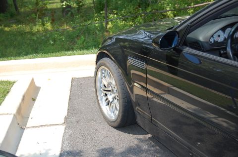 2002 BMW M3 - Side view of a black 2002 BMW M3, highlighting the front wheel and fender vent detail.