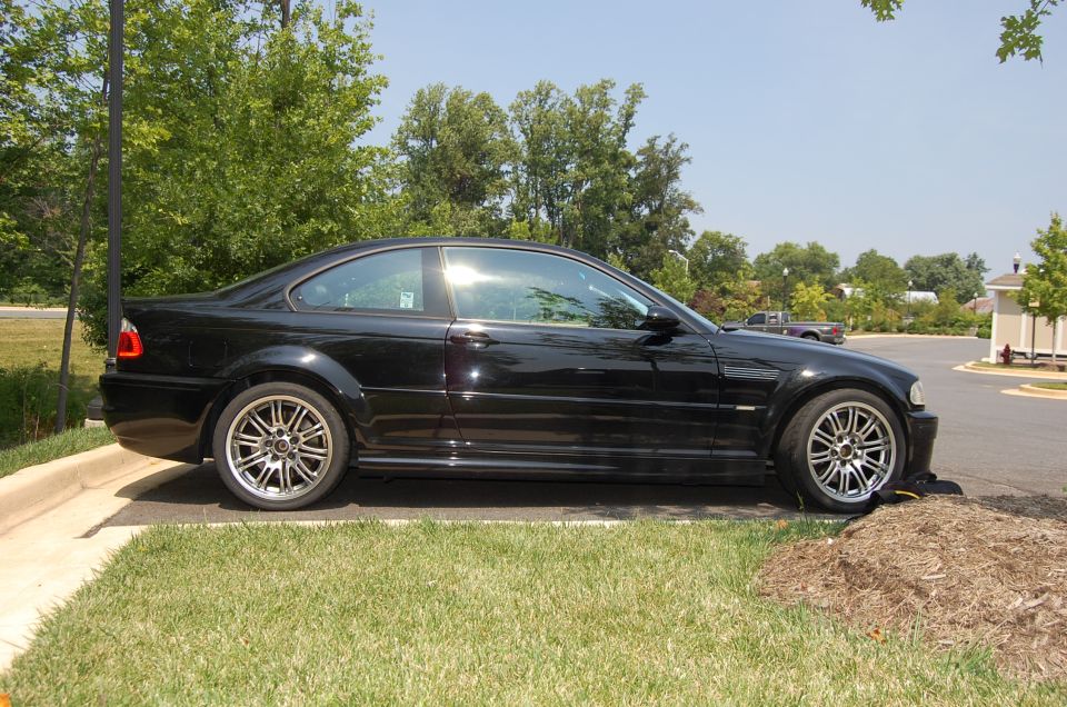Black 2002 BMW M3 coupe parked on grass and asphalt