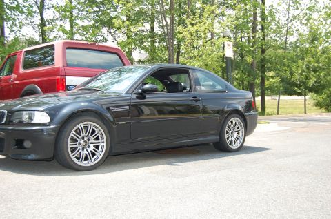 2002 BMW M3 - A black 2002 BMW M3 coupe is parked next to a red Ford Bronco.
