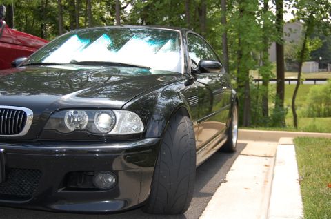 2002 BMW M3 - Front 3/4 view of a black 2002 BMW M3 with a wide tire, parked outdoors.