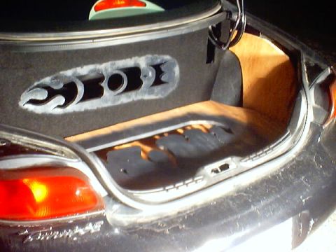 1999 Ford Taurus - The open trunk reveals custom wood paneling and cutouts in the carpeted side panel.