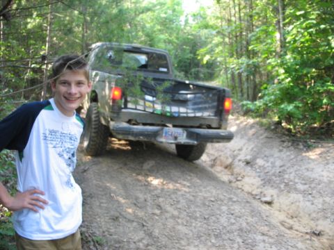 1978 Ford Bronco - Pickup truck navigating a dirt trail in a wooded area.