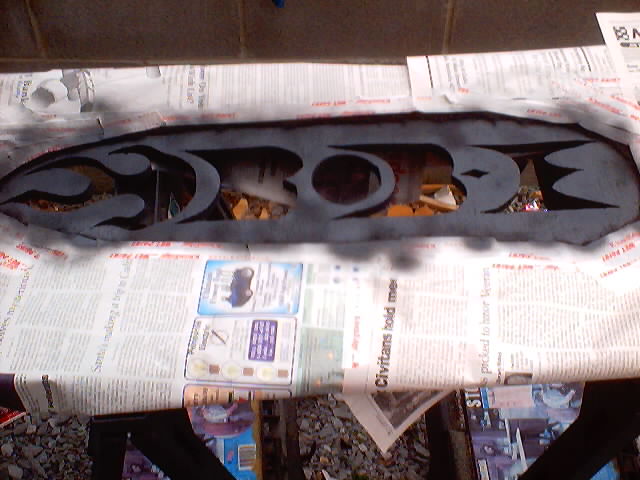 Custom grille insert with flame cutouts, being painted