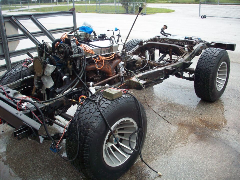Vehicle frame with engine, transmission, and wheels. Body is missing
