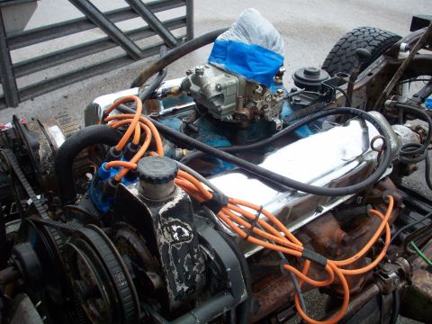 1978 Jeep CJ5 - The engine bay of a vehicle is shown, a carburetor and various engine components.