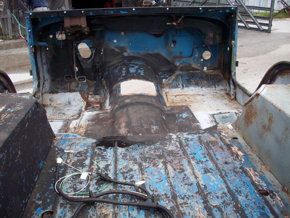 Blue 1978 Jeep CJ-5 tub interior, showing rusted floor and exposed wiring